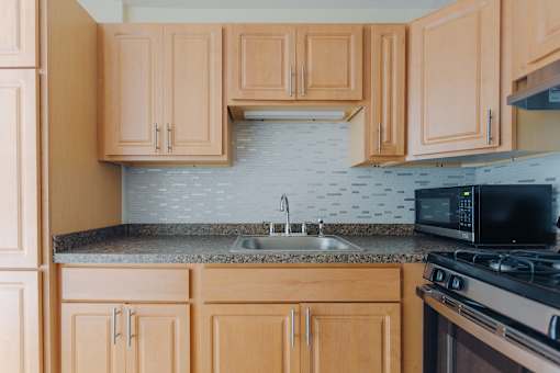 A kitchen with wooden cabinets and a black stove top oven.