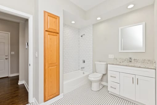 A bathroom with a toilet, sink, and a wooden door.
