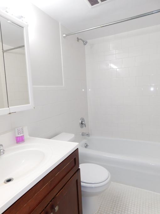 A white bathroom with a sink, toilet, and bathtub.