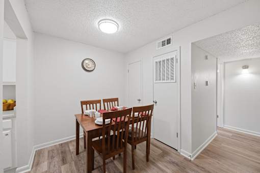 A dining room with a wooden table and chairs.