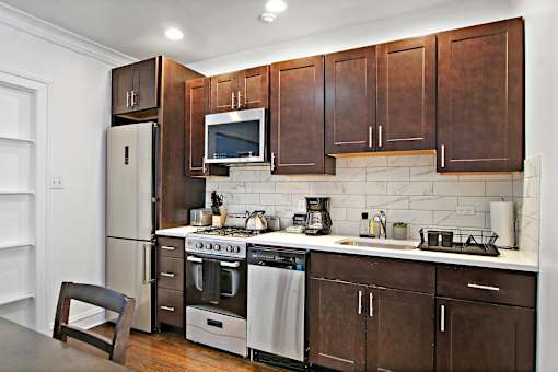 A kitchen with brown cabinets and stainless steel appliances.