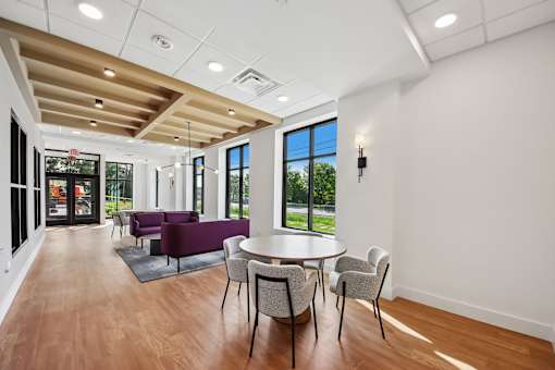 A room with a table and chairs and a window.
