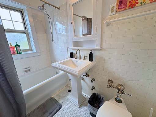 A white sink in a bathroom with a window.