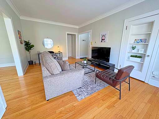 A living room with a grey couch and a brown chair.