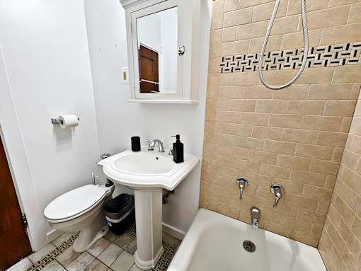 A bathroom with a toilet, sink, and bathtub.
