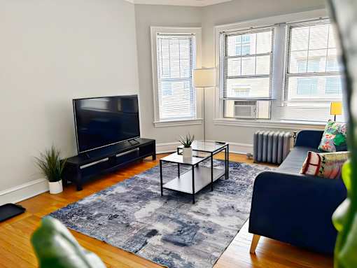A living room with a blue couch and a black television.