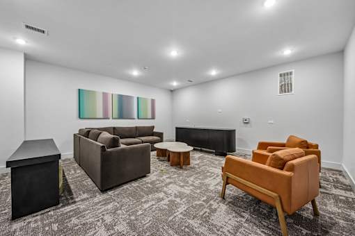 A living room with a grey carpet and furniture.