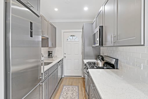 a kitchen with stainless steel appliances and white countertops