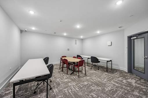 A conference room with a white table and chairs.