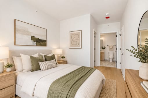 A bedroom with a bed, nightstand, and a painting on the wall.