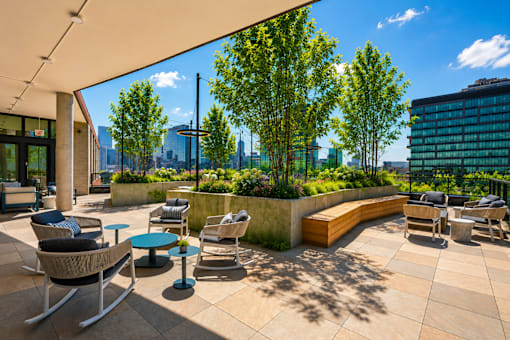 A patio with chairs and a table with a view of the city.