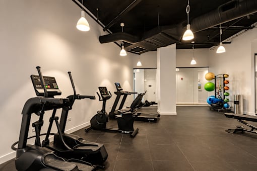 A gym with treadmills and exercise balls.