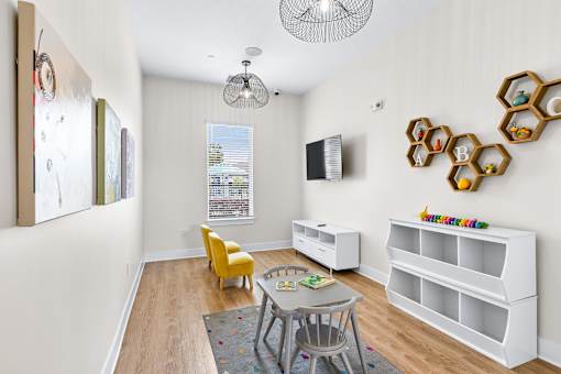 A living room with a yellow chair and a white shelf with toys on it.