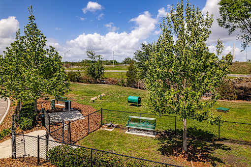 A park with a playground and a green bench.