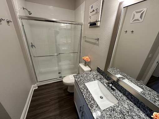 A bathroom with a sink, toilet, and shower.