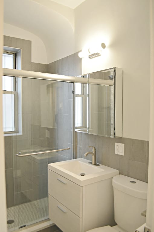 a small bathroom with a shower and a sink and a mirror