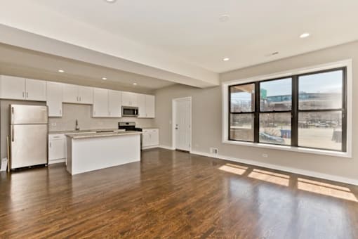 A spacious kitchen with white appliances and cabinets.