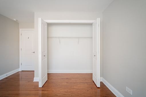 A room with a white door and a wooden floor.