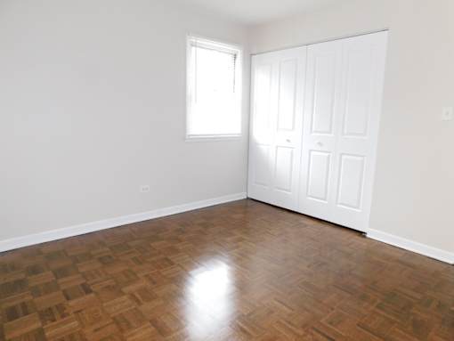 A room with a wooden floor and a white door.