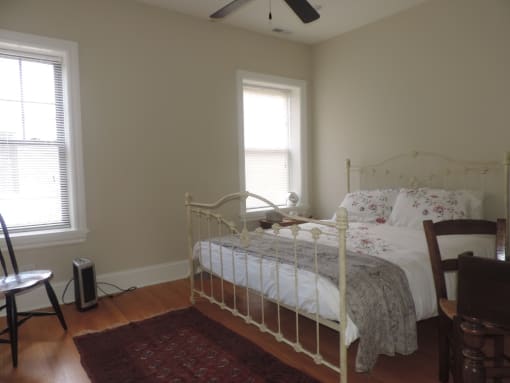 a bedroom with a bed and two windows