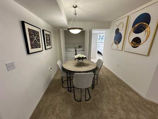 A dining room with a table and chairs.