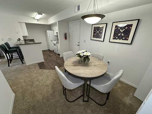 A dining room with a table and chairs.