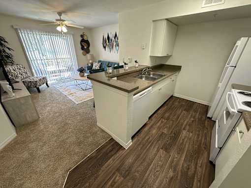 A kitchen with white cabinets and a wooden floor.