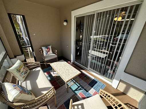 A sunny balcony with a table and chairs.