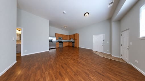 A large empty room with wooden floors and white walls.