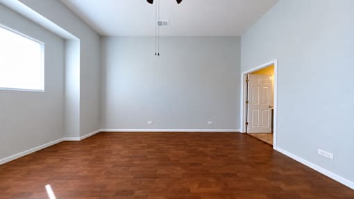 A room with a brown floor and white walls.