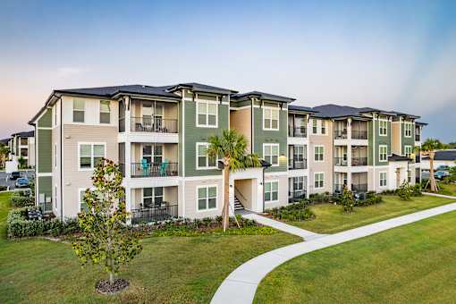 Apartment complex with a tree in front.