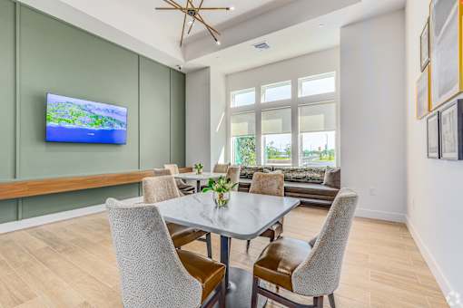 A modern dining room with a glass table and chairs.