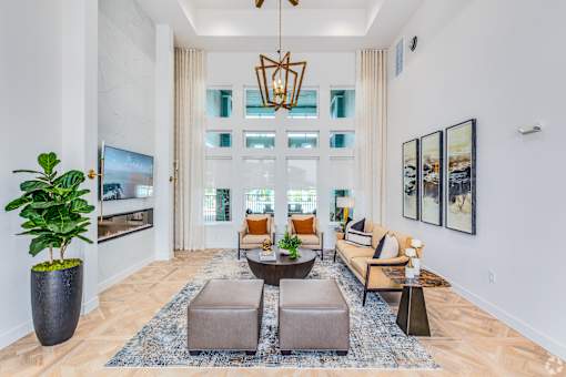 A living room with a large couch, a coffee table, and a TV.