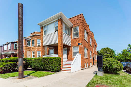 A red brick house with a white door and windows.