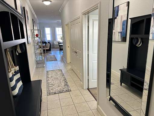 A hallway with a rug on the floor and a door on the right.