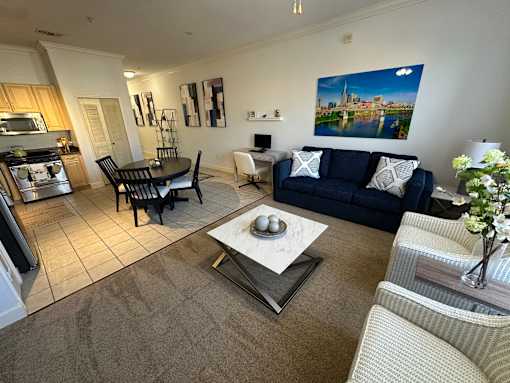 A living room with a blue couch and a coffee table in the center.