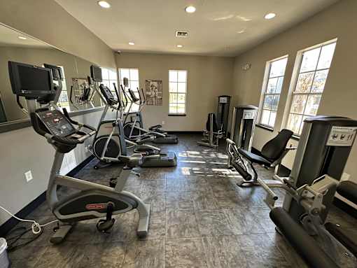 A gym with treadmills, elliptical machines, and other exercise equipment.
