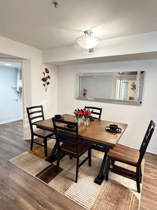A small room with a mirror and a wooden staircase.