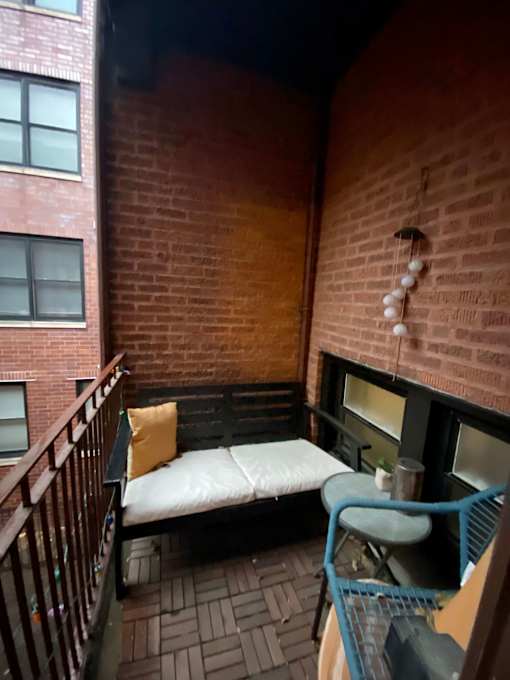 A small balcony with a bench and a table.