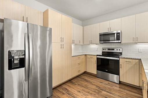 A kitchen with a stainless steel refrigerator and oven.
