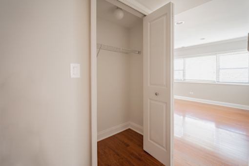 A white door is open to a room with a light switch on the wall.
