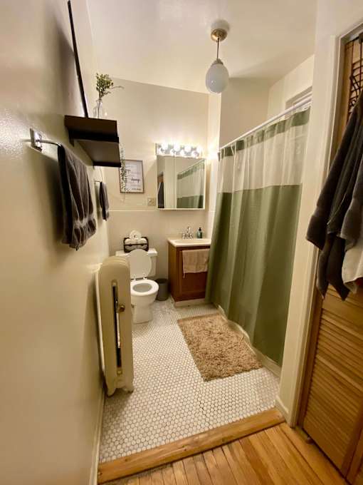 A bathroom with a toilet, sink, and a mirror.