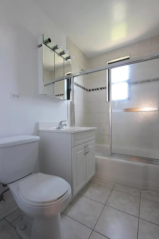 A white toilet sits next to a sink in a bathroom.