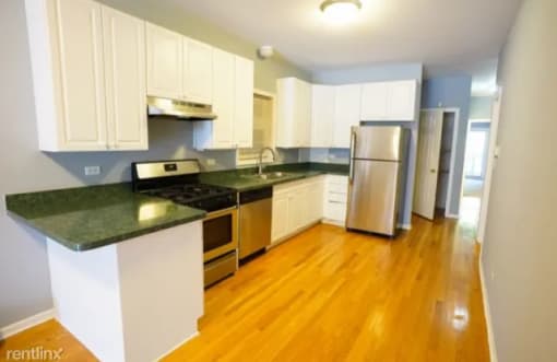 a kitchen with white cabinets and a stainless steel refrigerator