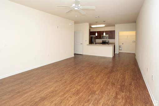 A room with wooden flooring and a ceiling fan.