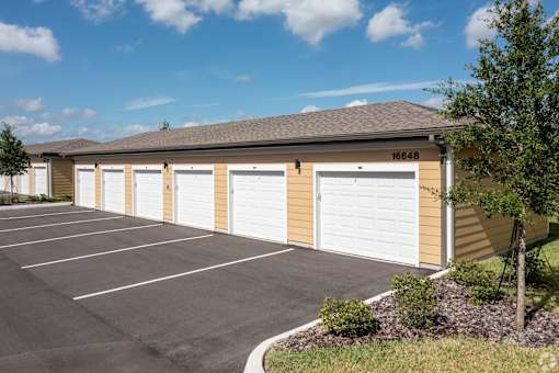 A building with the number 16648 on it has a row of white garage doors.