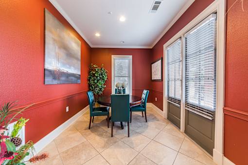 A dining room with a table and chairs.