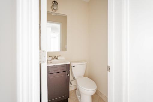 A white toilet sits next to a sink in a bathroom.