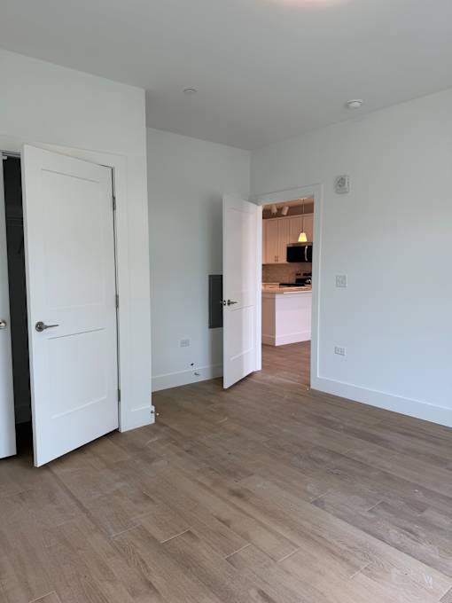 A white door is open to a kitchen.