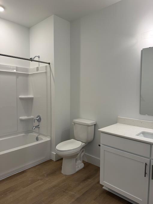 A white bathroom with a toilet, sink, and bathtub.